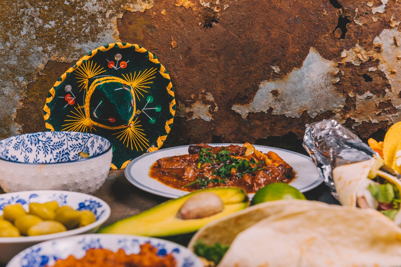 different delicious mexican dishes rusty background with mexican hat