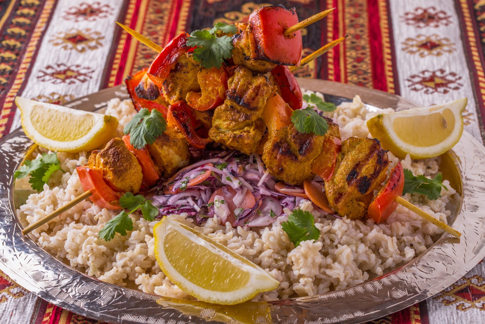 grilled chicken and vegetable kebabs served with rice and salad.